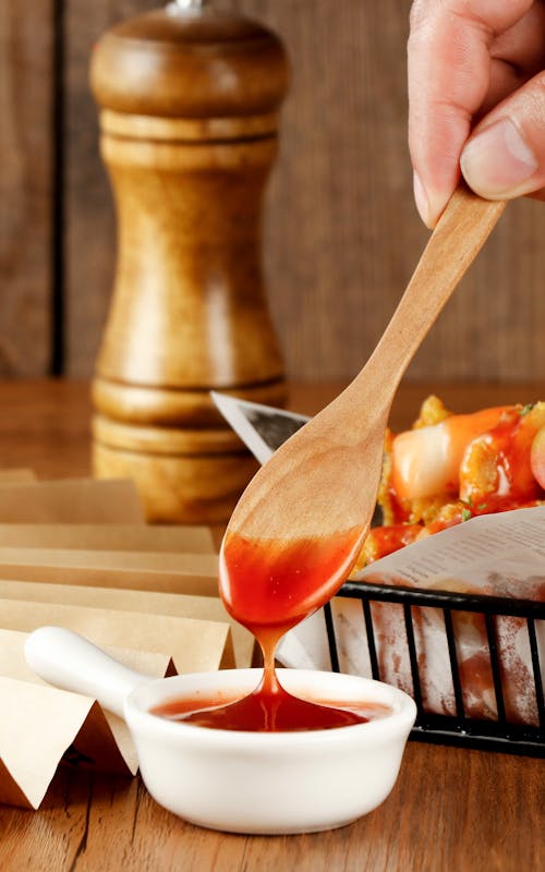 Free Person Dipping a Spoon in Sauce  Stock Photo