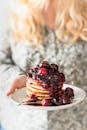 Person Holding White Ceramic Plate With Strawberry Cake