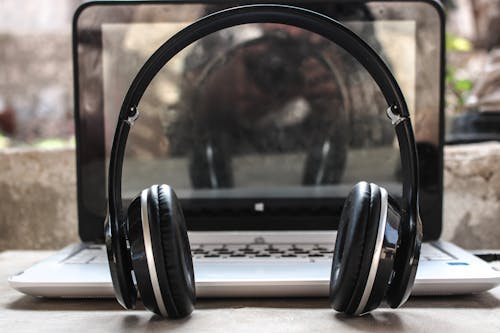 Free Photo of Black Wireless Headphones in Front of the Laptop Stock Photo