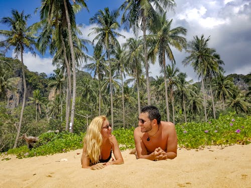 Free Man and Woman Lying on Sand Stock Photo