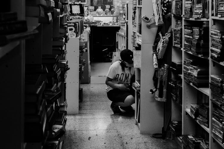 Woman Looking At Books At Thrift Store 