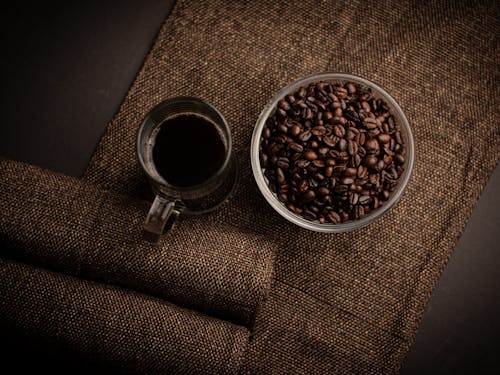 Free Coffee in Glass and Beans on Table Stock Photo
