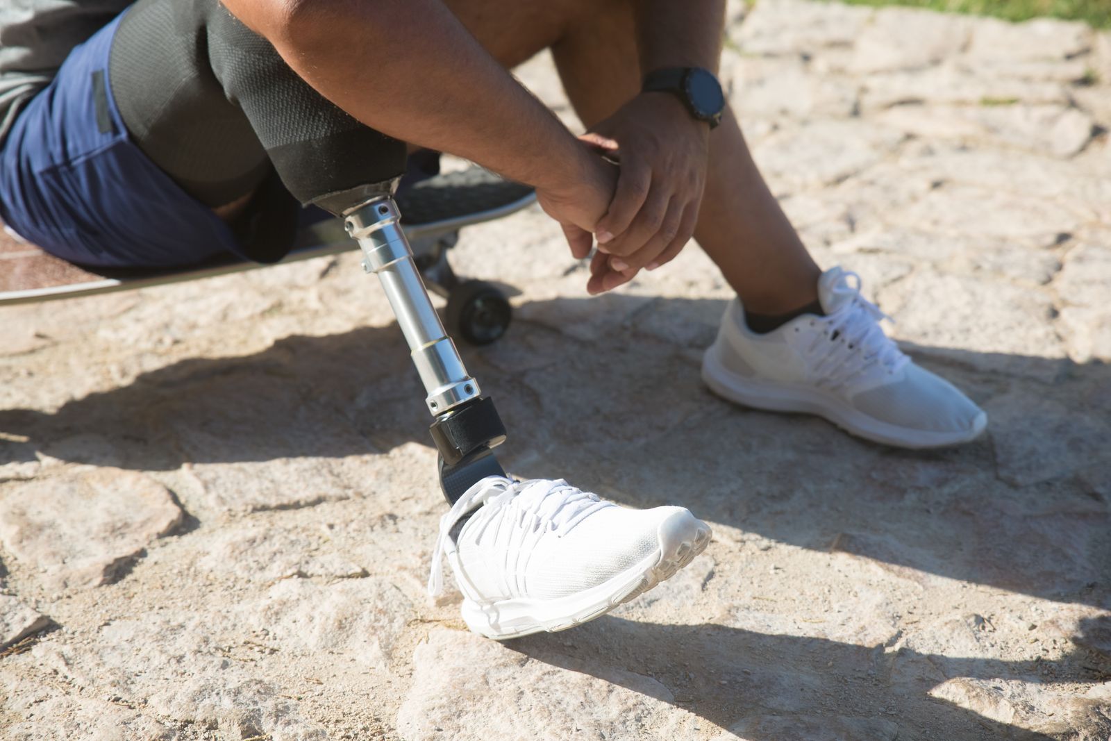 Person walking outdoors with a visible knee brace after a knee injury