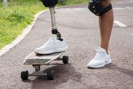 Person in White Nike Sneakers Riding on Black and Gray Kick Scooter