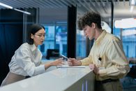 Recpetionist helping Man Fill Out Papers
