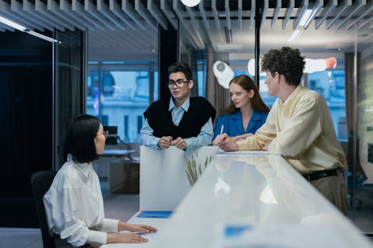 A diverse group of professionals engaged in teamwork and collaboration within a modern office setting.