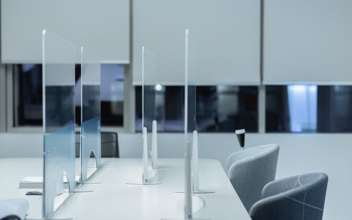 Contemporary office setting with stylish chairs and desk dividers, perfect for productivity.