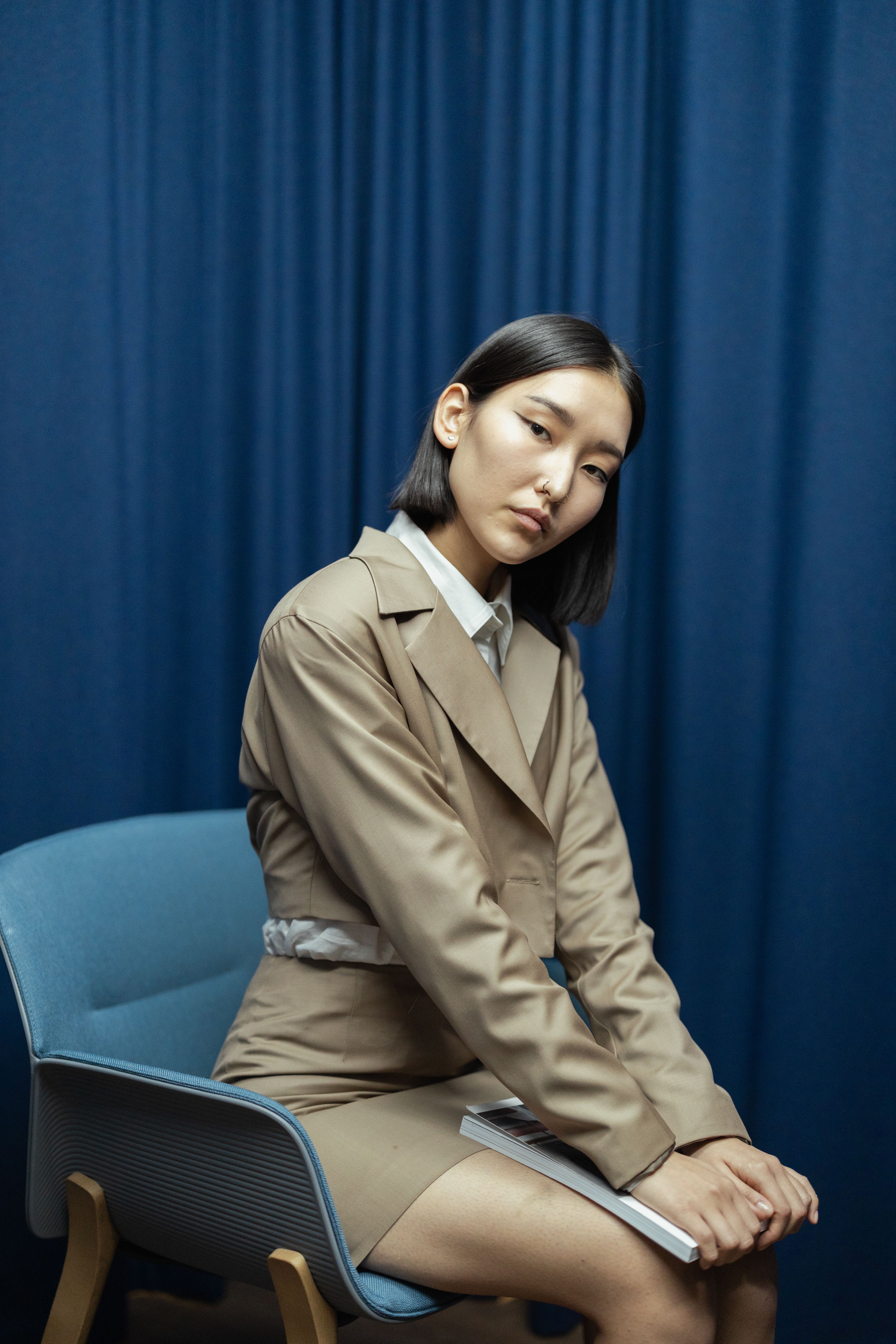 Woman in Brown Coat Sitting on Blue Chair · Free Stock Photo