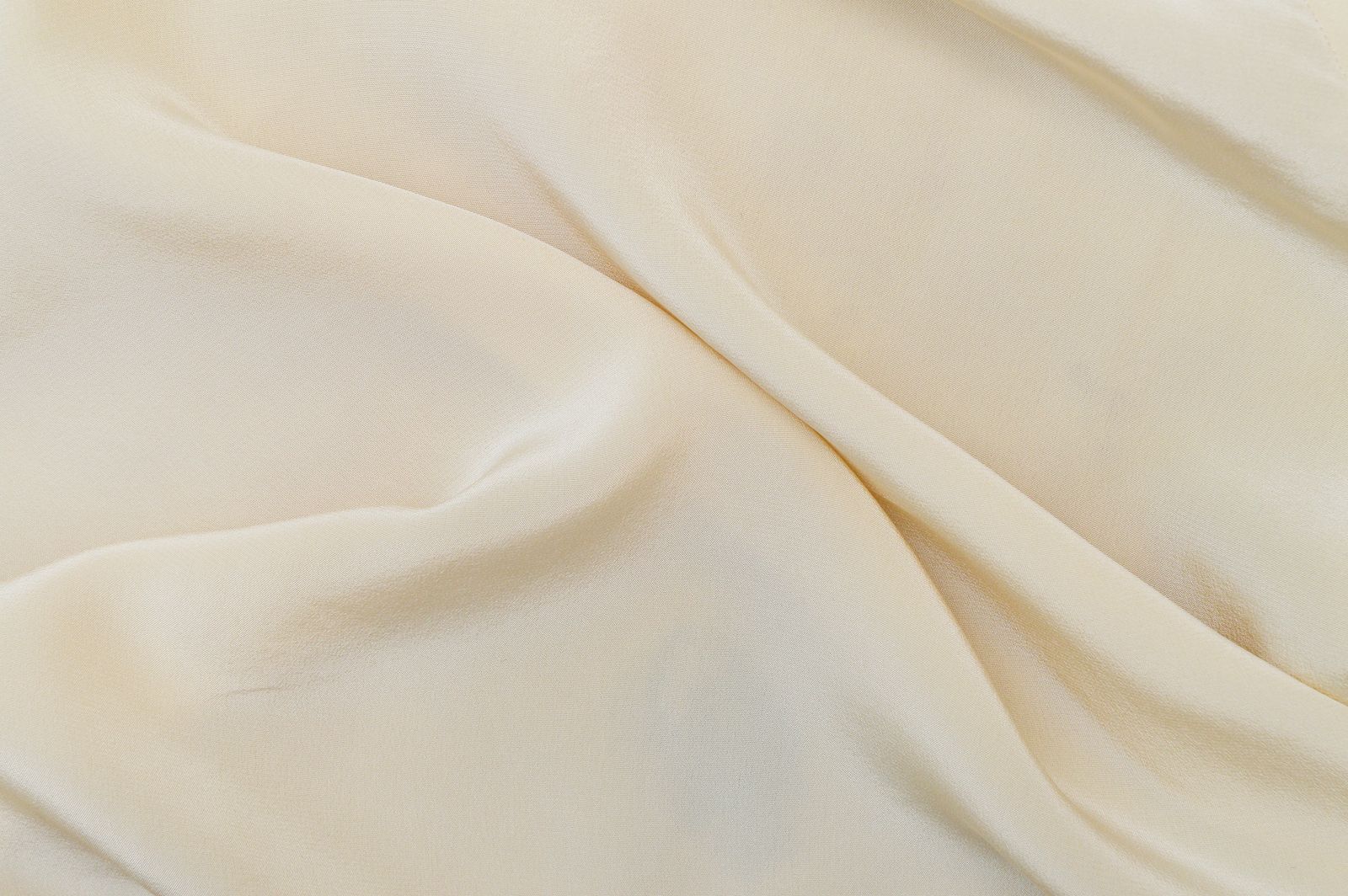 Soft off-white fabric folded into slow waves — photo by Davis Vidal on Pexels