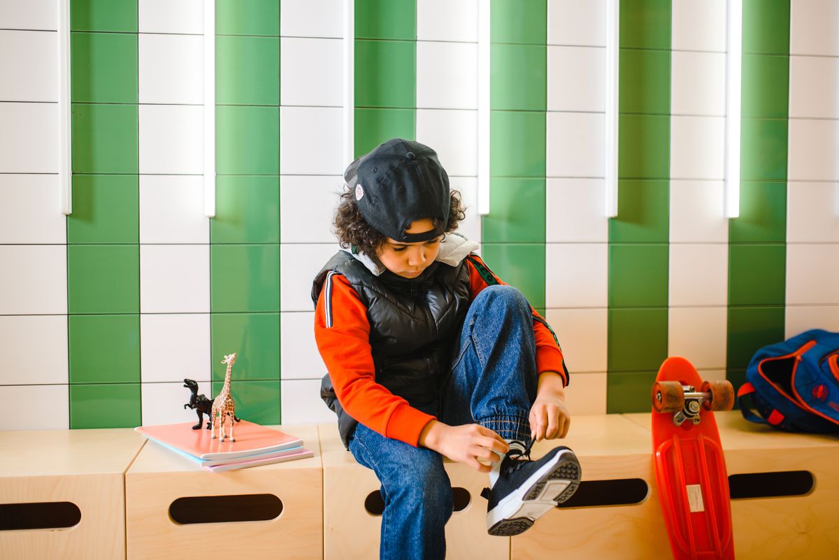 Kinder selbstständig machen: Junge bindet seine Schuhe selbst