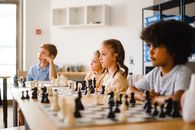 Boy and Girl Playing Chess on Table