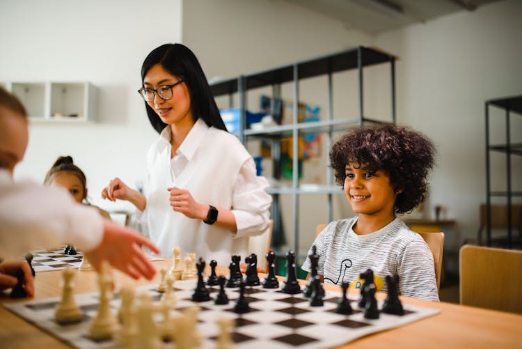 Teacher And Students During Chess Lesson