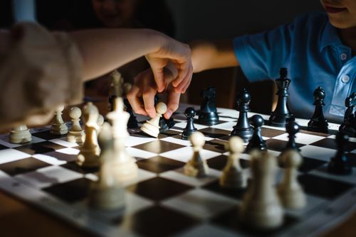 Free Hands engaging in a strategic chess game, showcasing concentration. Perfect for themes of intelligence and strategy. Stock Photo