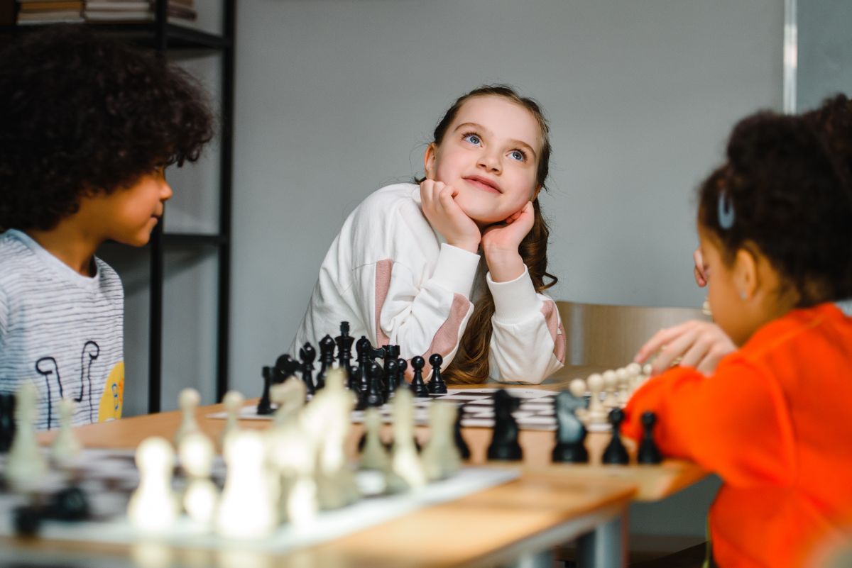 Kids learning to play chess on family game night