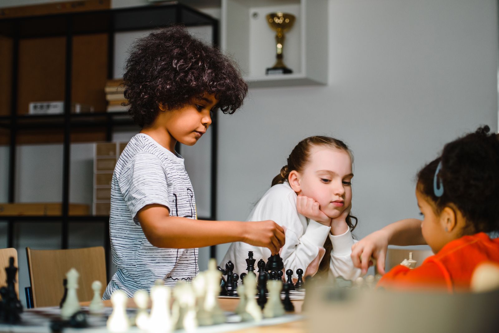 Children learning and playing chess