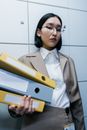 Woman in White Blazer Holding Yellow Ipad Case