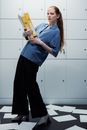 Woman in Blue Shirt and Black Pants Holding Yellow and White Labeled Bottle