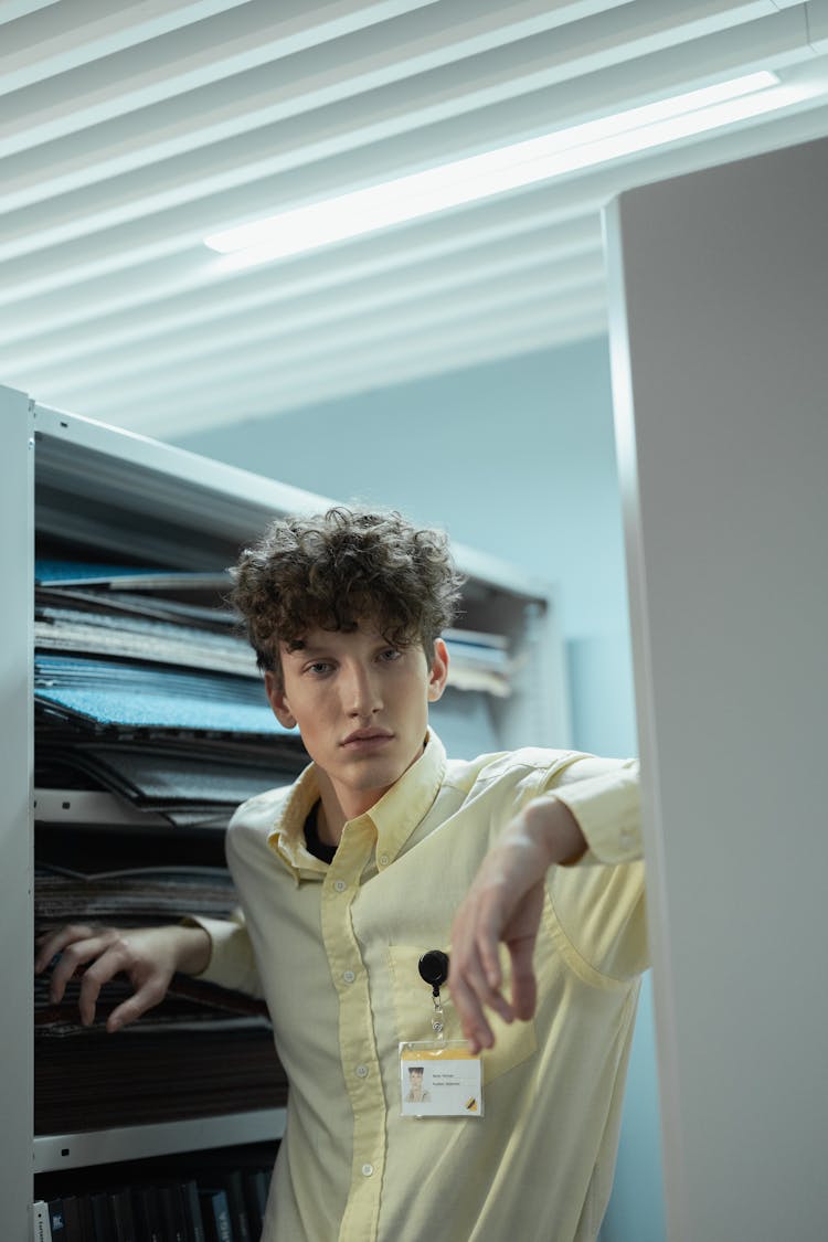 Man In Yellow Dress Shirt Standing Near A File Cabinet