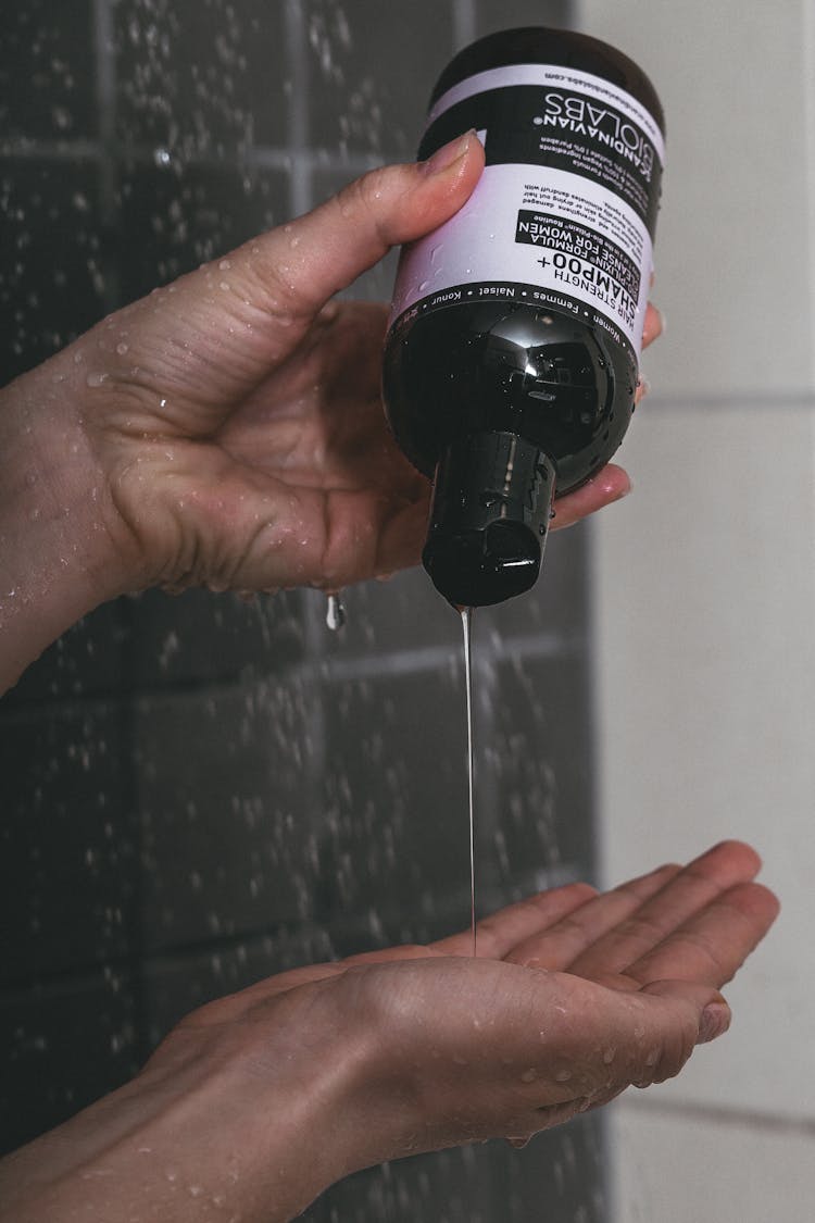 A Person Holding A Bottle Of Shampoo