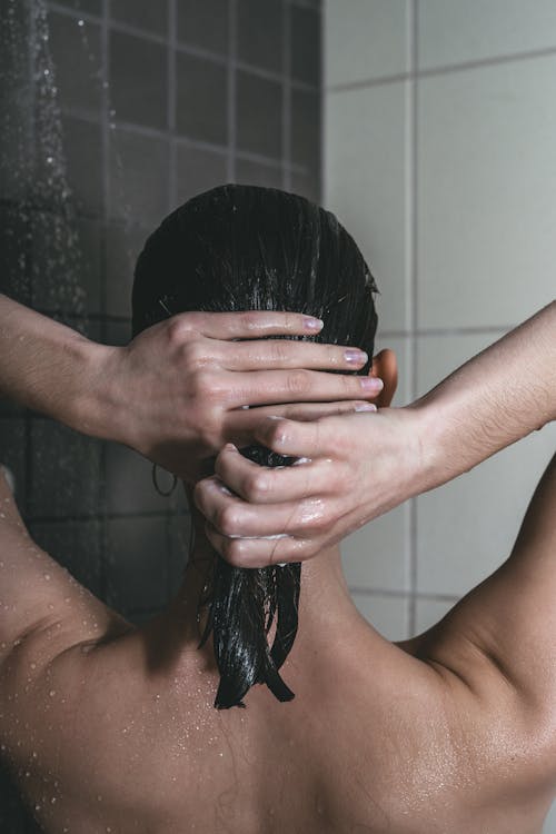 Free A Topless Woman Shampooing Her Hair Stock Photo
