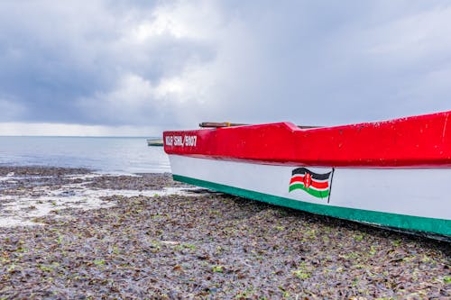 Red and Green Boat on Beach Shore
