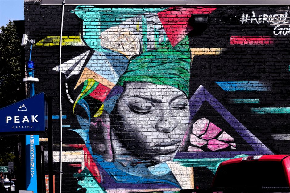 Vibrant mural of a woman on a brick wall showcasing modern street art style.