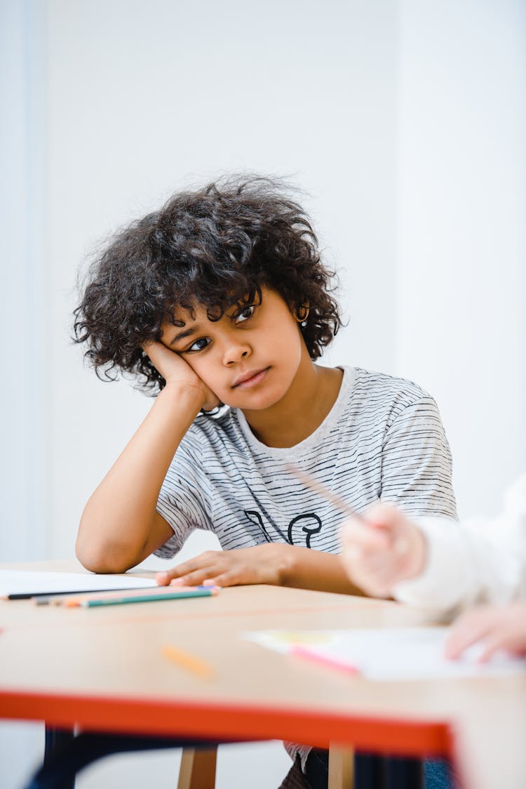 A Child Leaning On The Table