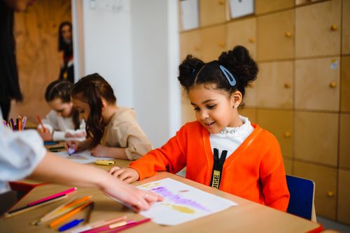 Free Young students happily enjoying art projects in a classroom setting. Stock Photo