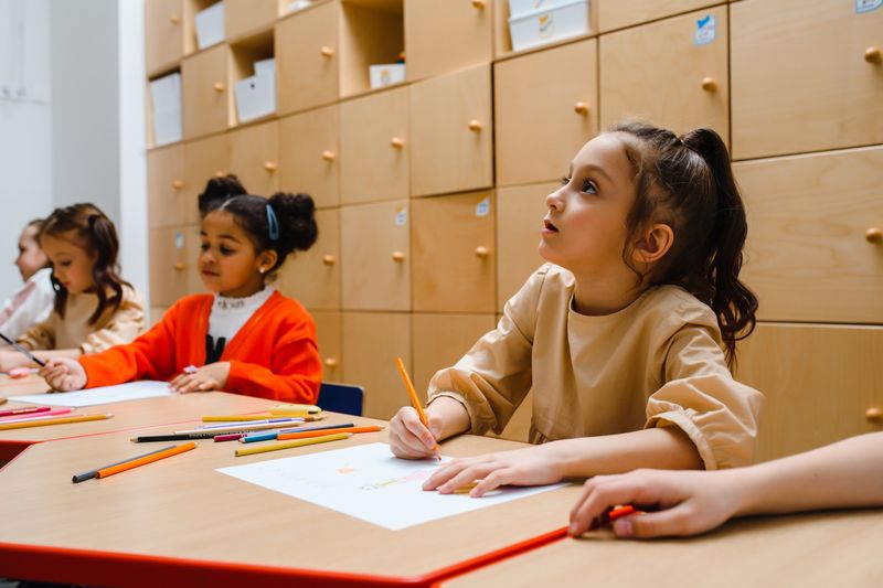 Children participating in a creative classroom writing session indoors. Education and learning environment.