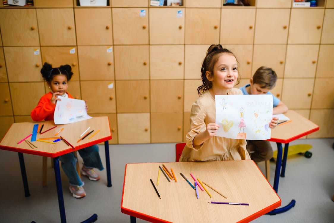 Girl Showing Artwork While Standing in the Classroom