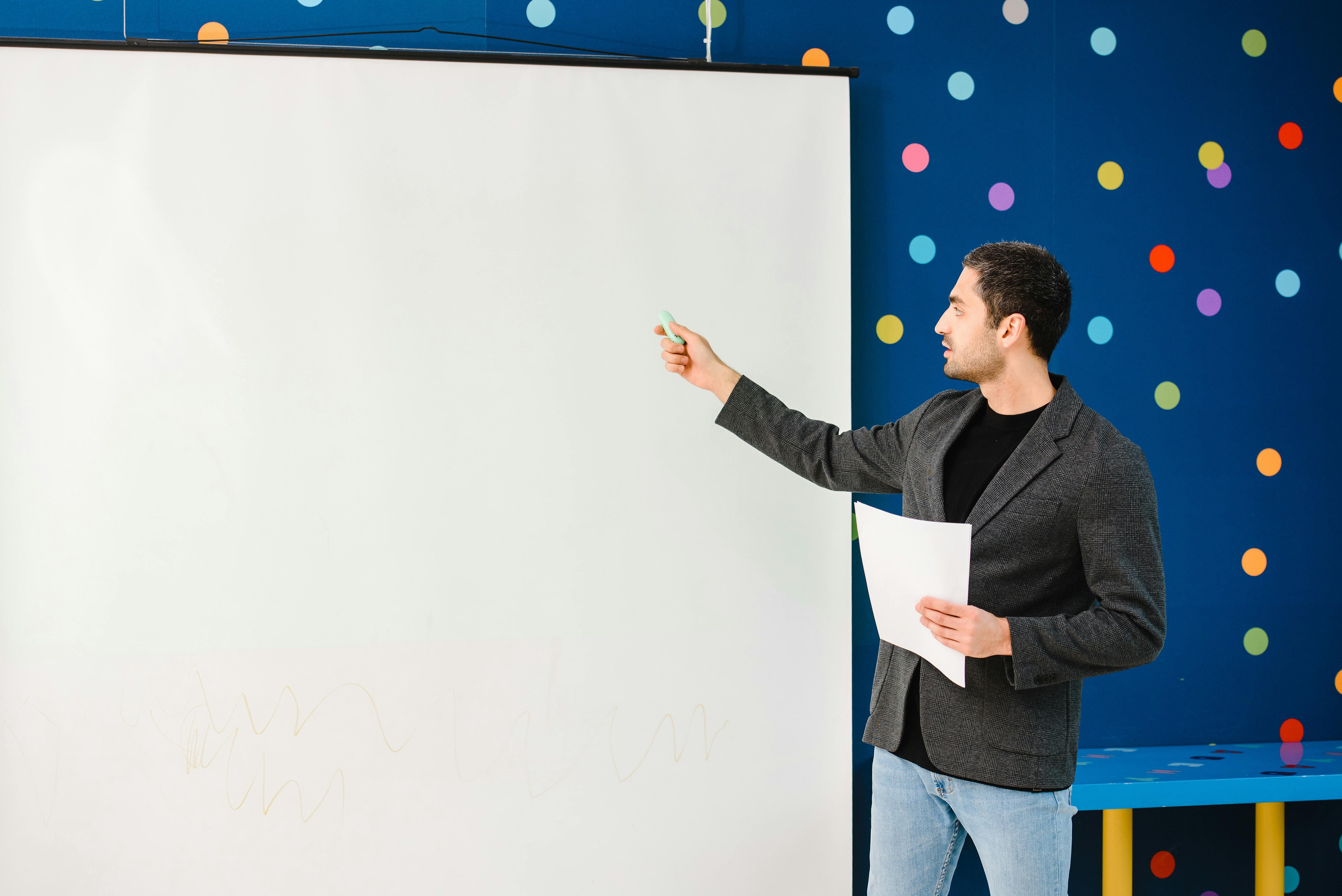 Teacher Pointing at a Projector Screen · Free Stock Photo