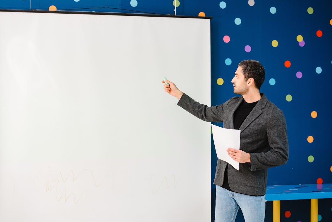 Teacher Pointing at a Projector Screen
