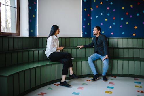 Man and a Woman Having a Conversation inside a Classroom