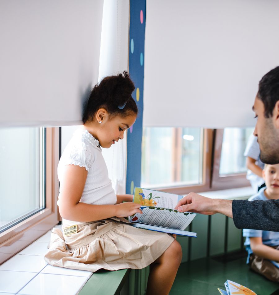 Teacher and child sharing a positive reading activity
