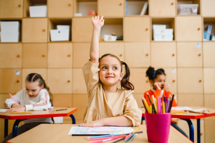 Girl Raising Hand Inside The Classroom