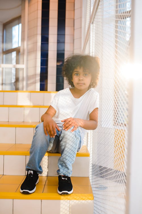 Free Boy Sitting on a Yellow Staircase Stock Photo