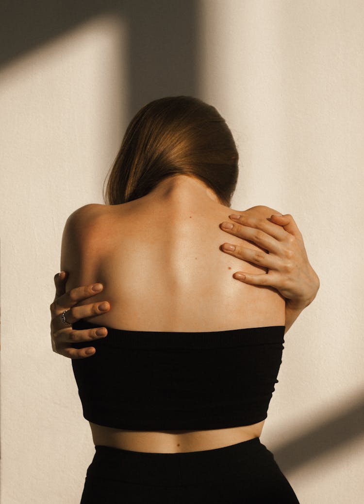 Back View Of A Woman Reaching Her Back