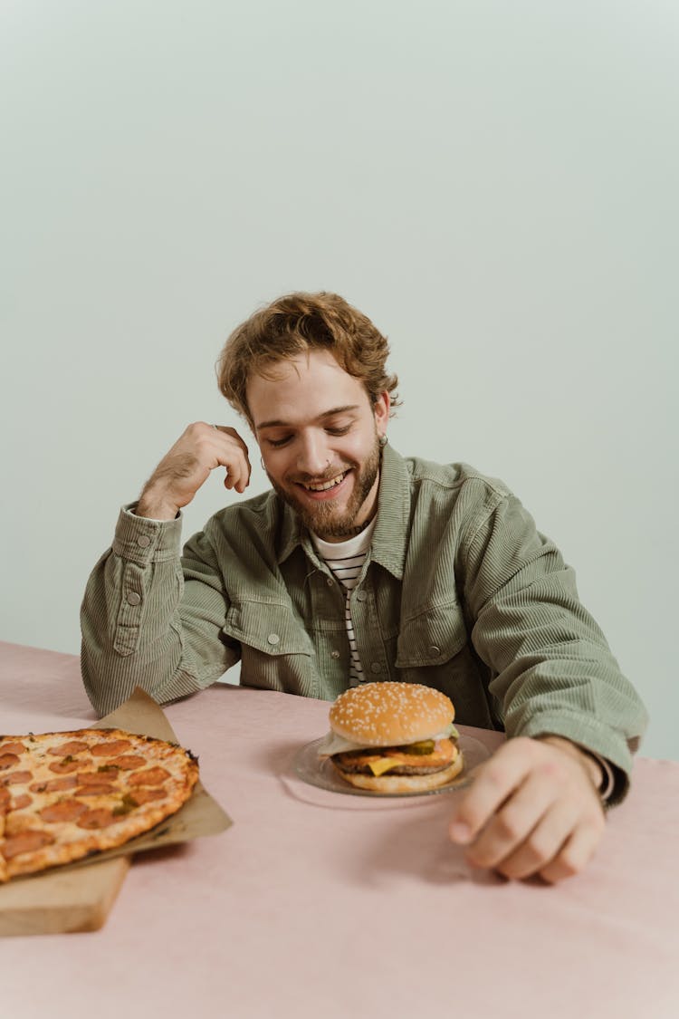 Man Looking At A Burger In The Table