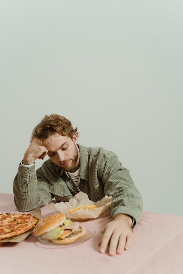 Bored Man Looking At The Foods In The Table