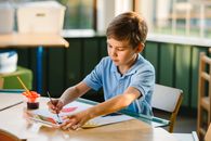 Boy in Blue Polo Shirt Writing on White Paper