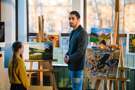 Art instructor guiding students in a vibrant classroom setting with paintings on display.