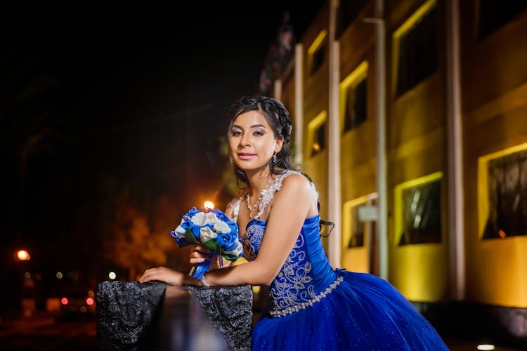 Woman In Blue Quince Dress Holding A Bouquet Of Flowers