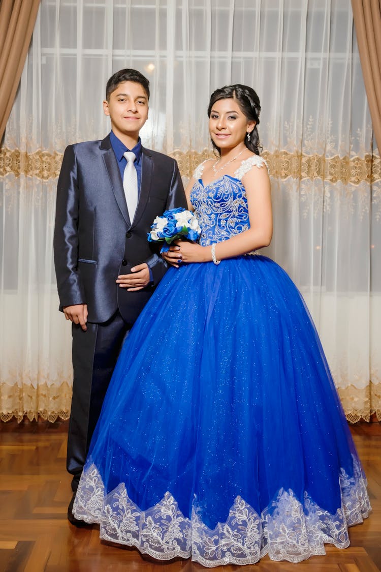 Young Man In Blue Suit And Woman In Blue Quince Dress