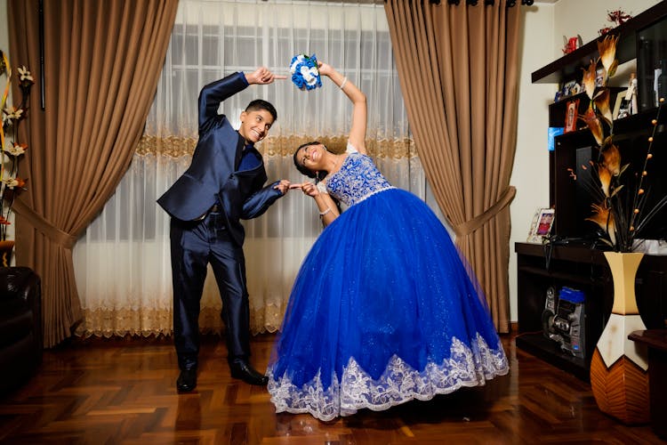 Young Man In Blue Suit Dancing With A Woman In Blue Quince Dress