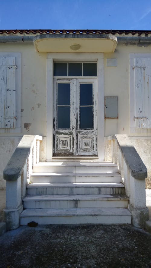 Free Exterior of an Old Building With Stairs To A White Wooden Grunge Door  Stock Photo