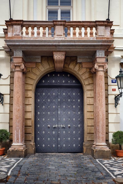 Free A classical architectural doorway with ornate columns and a balcony above. Stock Photo