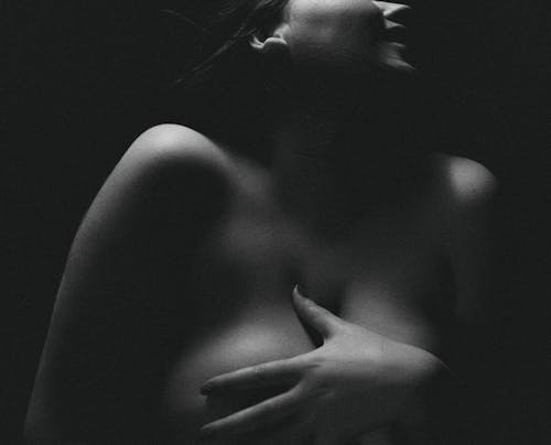 Grayscale Photo of Naked Woman With Her Hands on Her Body