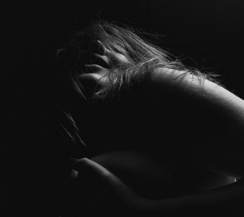 Free A sensual and mysterious black and white portrait capturing a woman in artistic shadows. Stock Photo