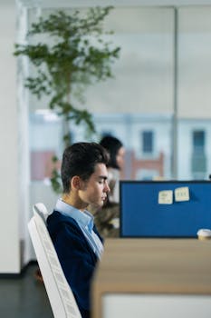 Focused man working in a modern office setting during the day.