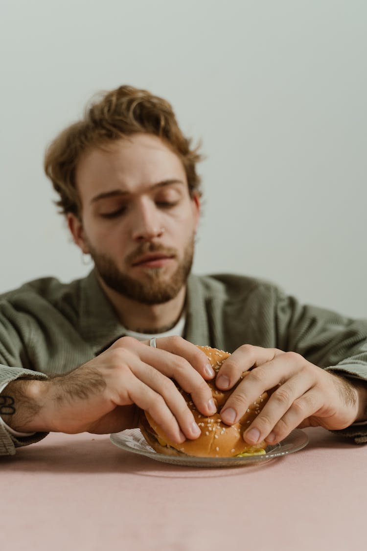 Man Holding Hamburger From A Plate